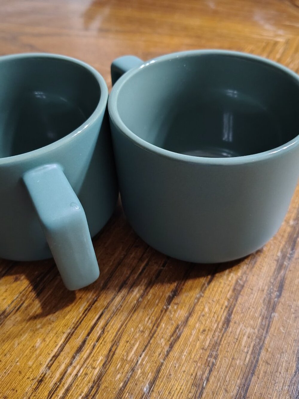 two green ceramic mugs